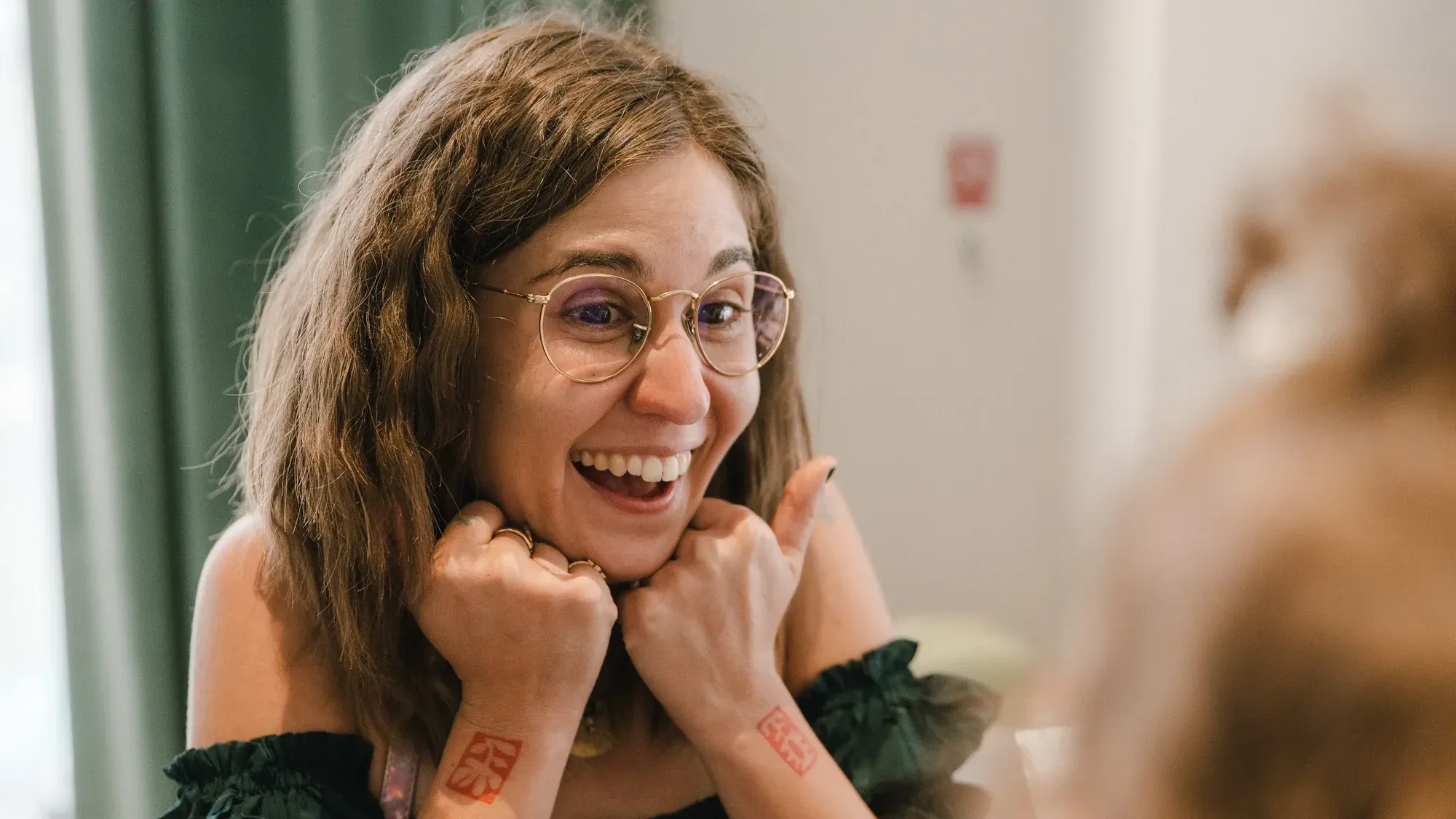 Meda Andreea Căpîlna râzând, cu ochelari, sprijinindu-și bărbia în mâini